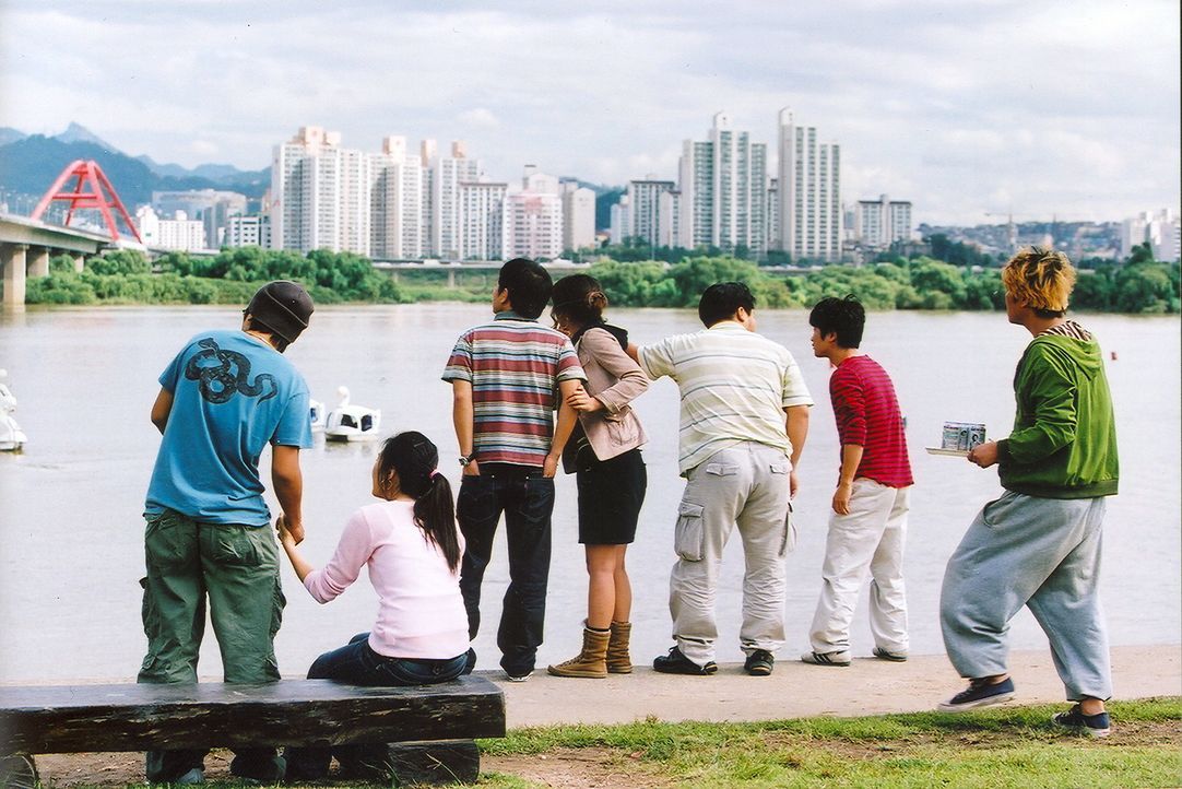 Am Ufer des Han-Flusses drängelt sich eine Schar von Schaulustigen, um nach dem Monster Ausschau zu halten, das gerade ins Wasser gesprungen ist ... - Bildquelle: MFA