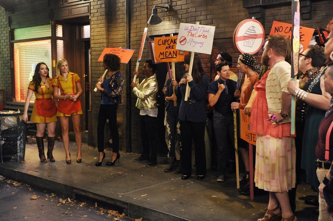 Sind Caroline (Beth Behrs, 2.v.l.) und Max (Kat Dennings, l.) wirklich schwulenfeindlich? Das behaupten zumindest die Demonstranten, die sich vor de... - Bildquelle: Warner Brothers