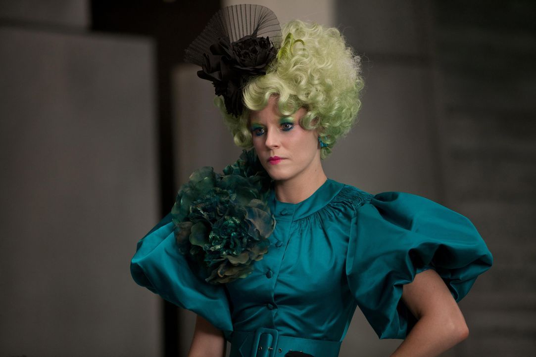 Katniss' und Peetas Betreuerin ist Effie Trinket (Elizabth Banks). Sie trägt immer eine Perücke in einer knalligen Farbe und dazu passendes Makeup... - Bildquelle: Studiocanal GmbH