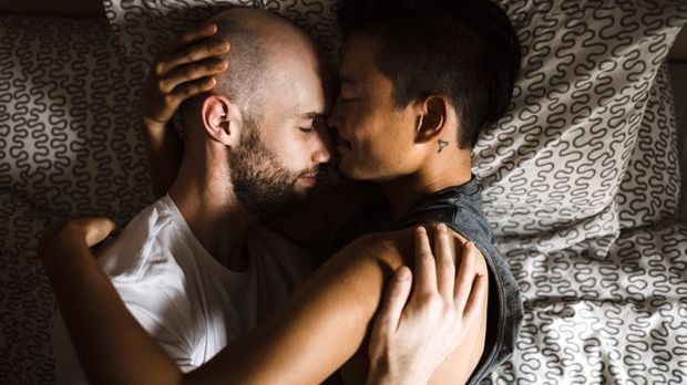 Paar liegt zusammen im Bett