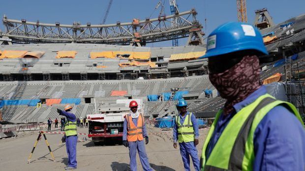 Arbeiter stehen in einem Stadion in Katar.
