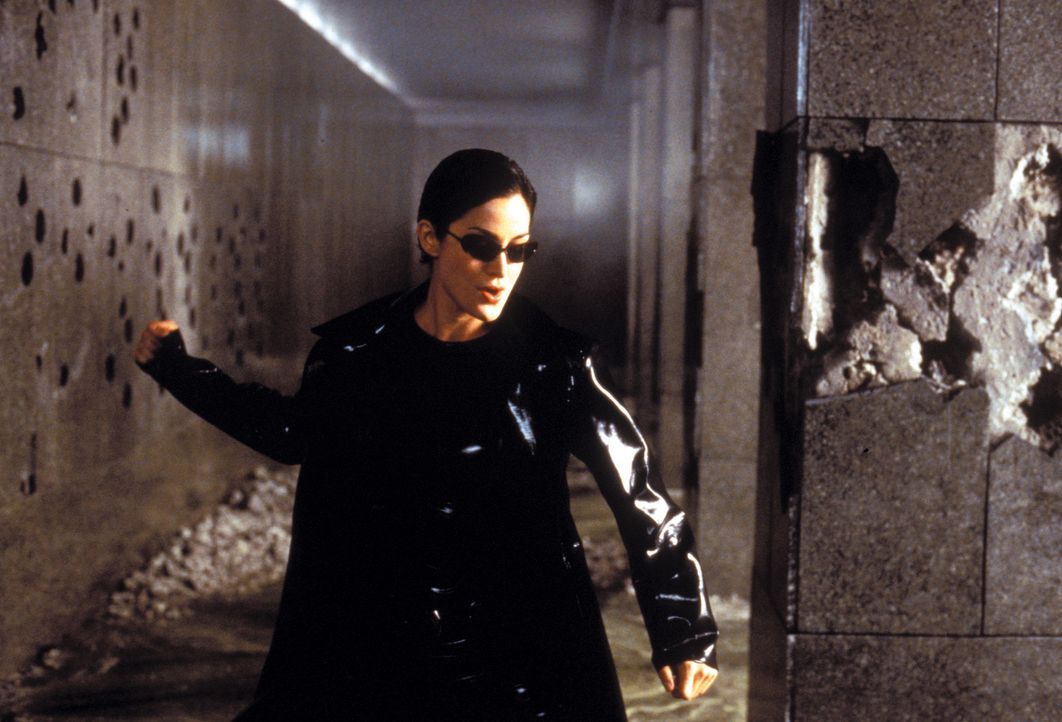 Zusammen mit Neo zerlegt die gefährlich schöne Trinity (Carrie-Anne Moss) die Eingangshalle eines Polizeigebäudes, inklusive Wachpersonal, in sei... - Bildquelle: Warner Bros. Pictures