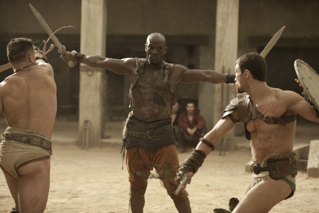 Drago (Peter Mensah, M.) ist der einzige Mann, der einen Kampf gegen Theokoles überlebt hat. Nun bereitet er Spartacus (Andy Whitfield, r.) und Cri... - Bildquelle: 2010 Starz Entertainment, LLC