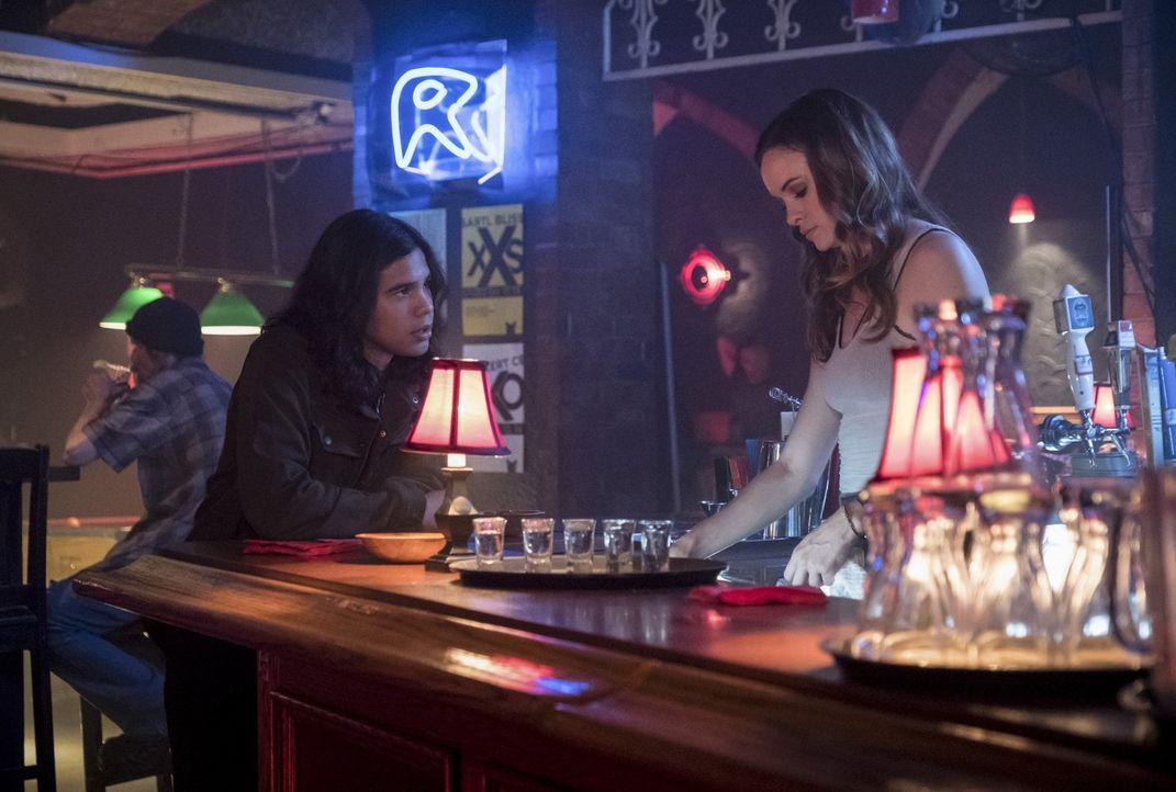 Cisco (Carlos Valdes, l.) stattet Caitlin (Danielle Panabaker, r.) einen Besuch in der Kneipe ab, in der sie arbeitet und weiht sie in ihre Pläne ei... - Bildquelle: 2017 Warner Bros.