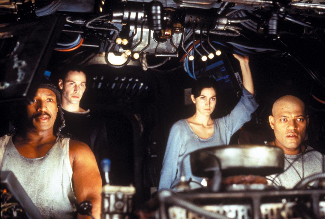 Neben Dozer (Anthony Ray Parker, l.), Trinity (Carrie-Anne Moss, 2. v. r.) und ihrem Captain Morpheus (Laurence Fishburne, r.), gehört auch Neo (Ke... - Bildquelle: Warner Bros. Pictures