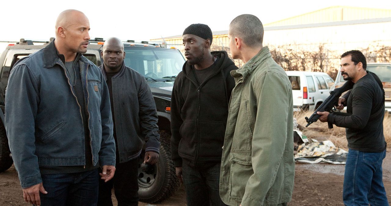 Daniel (Jon Bernthal, 2.v.r.) vermittelt John (Dwayne Johnson, l.) einen Kontakt zum Dealer Malik (Michael Kenneth Williams, M.), der sich die LKWs... - Bildquelle: TOBIS FILM