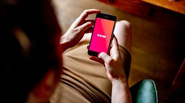 Frau nutzt über ihr Smartphone Tinder.