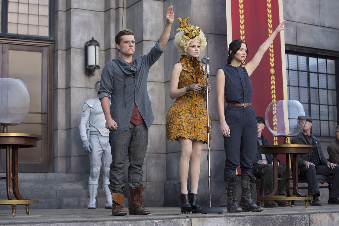 Auch Effie (Elizabeth Banks, M.) kann ihre "Zöglinge" Katniss (Jennifer Lawrence, r.) und Peeta (Josh Hutcherson, l.) nicht davon abhalten, deutlich... - Bildquelle: Studiocanal GmbH