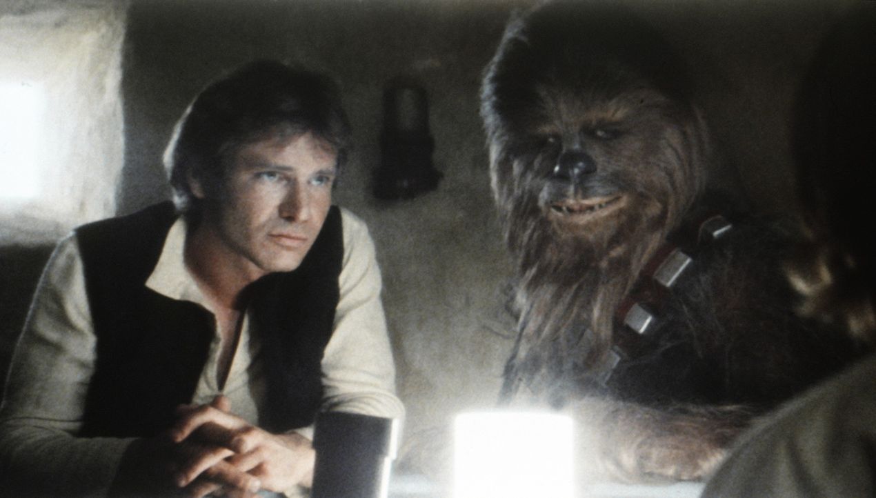 Han Solo (Harrison Ford, l.) und Chewbacca (Peter Mayhew , r.) sollen Obi-Wan Kenobi und Luke Skywalker mit ihrem Raumschiff "Rassender Falke" zu de... - Bildquelle: Lucasfilm LTD. & TM. All Rights Reserved.